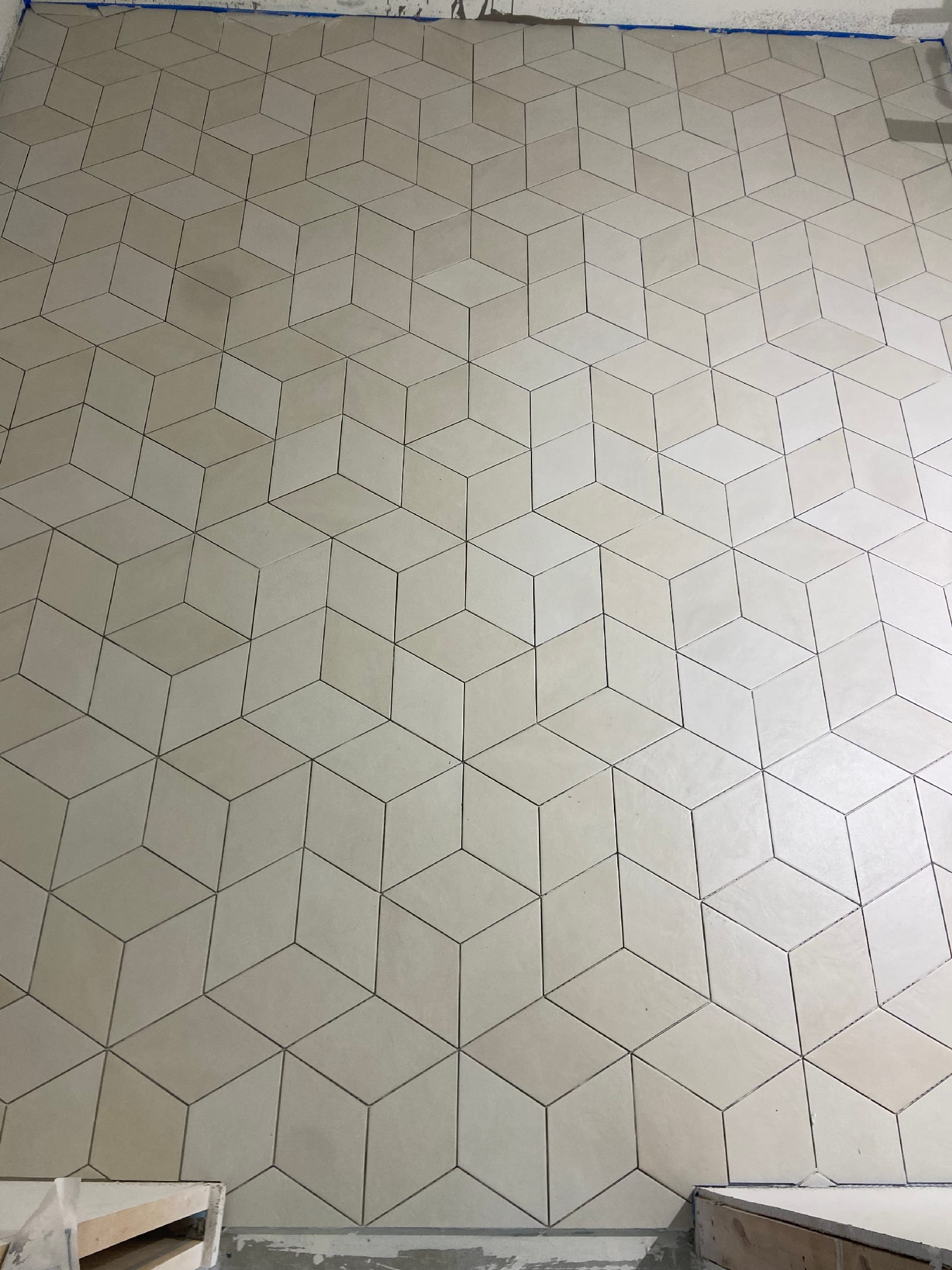 Cream-colored rhombus tile floor laid in a three-dimensional cube pattern.